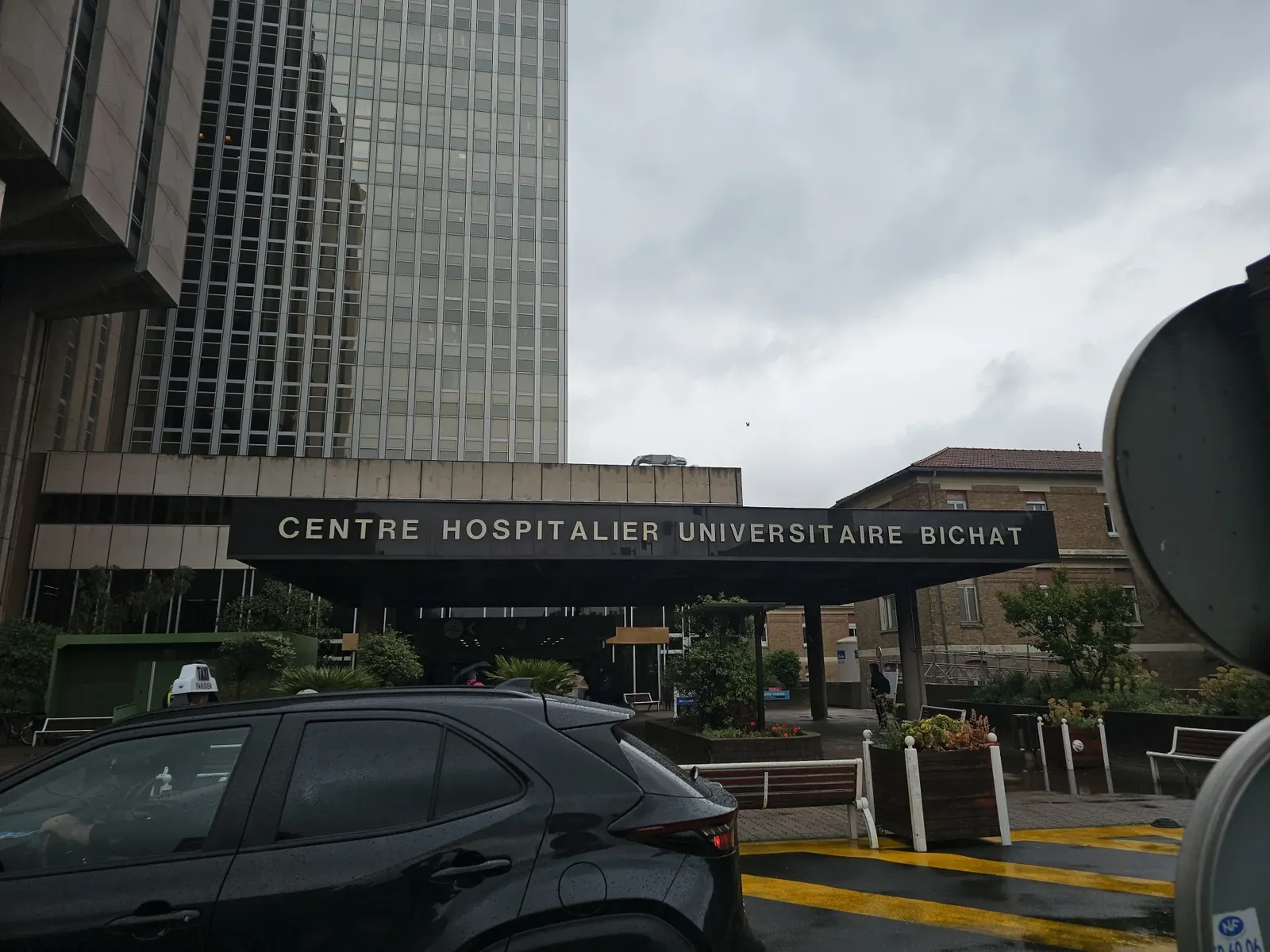 Entrée d'un centre hospitalier universitaire, trajet en taxi vers un établissement de santé